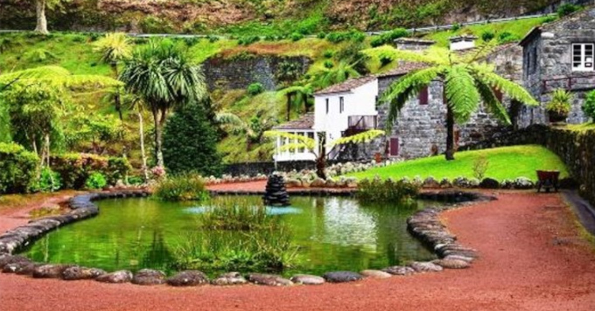 Vista verdejante para lago e casas típicas Açorianas